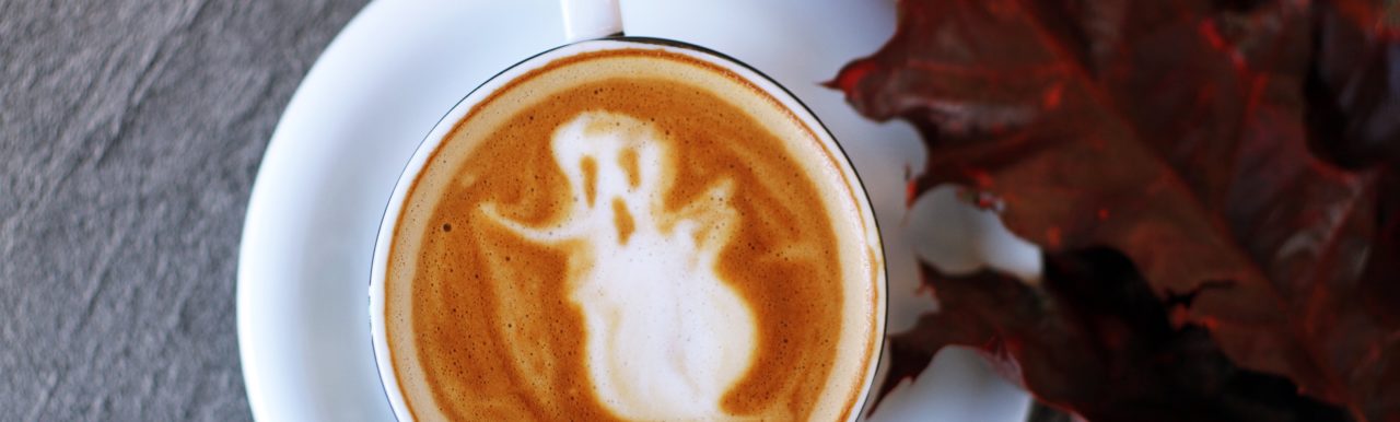 Halloween-spøkelse i skummet på ein kaffikopp. Foto.